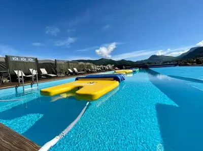 a swimming pool with blue water and yellow slides at Ladebua in Brunstad