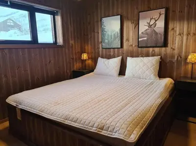 a bedroom with a bed with a deer on the wall at Ladebua in Brunstad