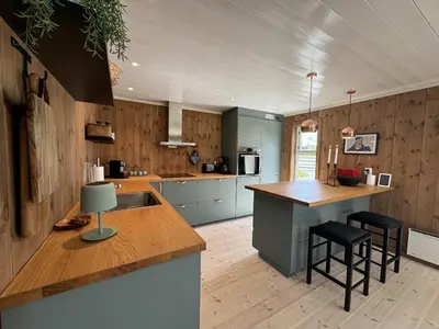 a kitchen with a sink and a counter with stools at New and cozy family cabin on Golsfjellet in Golsfjellet