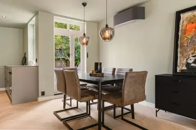 a dining room with a black table and chairs at Bryggen // Fløyen Living in Bergen
