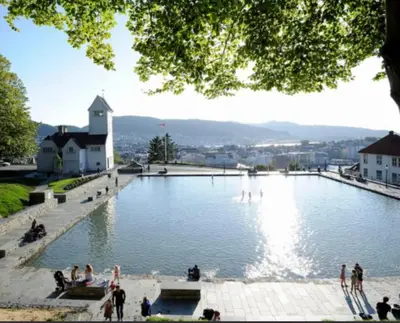 a large pond with a fountain in the middle at Byleilighet nær Fløyen in Bergen