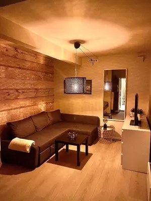 a living room with a brown couch and a table at Byleilighet nær Fløyen in Bergen