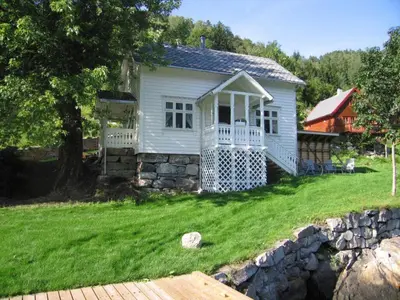 a small white house with a stone wall at 