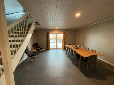 a dining room with a table and chairs and a staircase at Rorbu i Bud Havn in Bud