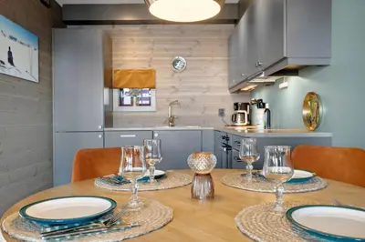 a kitchen with a table with plates and glasses on it at Riddertunets lune leilighet - dyr tillatt in Beitostøl