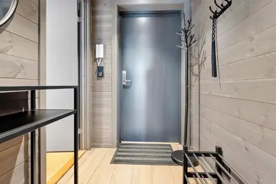 a steel door in a hallway with a wooden floor at Riddertunets lune leilighet - dyr tillatt in Beitostøl