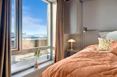 a bedroom with a bed and a large window at Riddertunets lune leilighet - dyr tillatt in Beitostøl