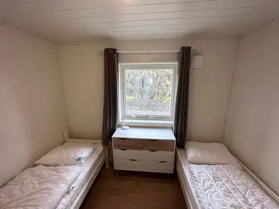 two beds in a small room with a window at Moderne feriehus i Bud in Bud