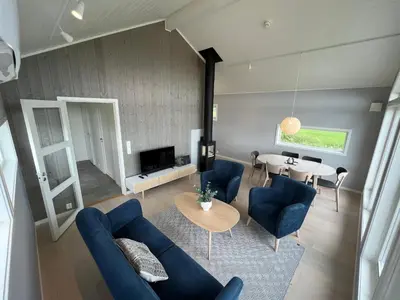 a living room with a blue couch and a table at Moderne feriehus i Bud in Bud