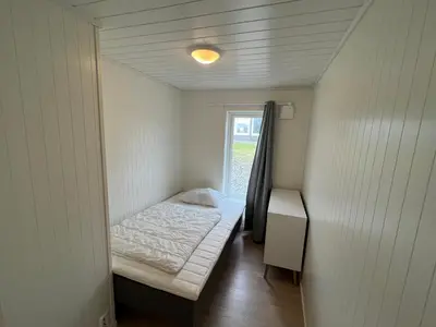 a small room with a bed and a window at Moderne feriehus i Bud in Bud