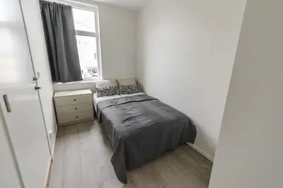 a small bedroom with a bed and a window at 7 Soverom i hjertet av Bergen in Bergen