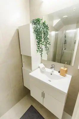 a bathroom with a white sink and a mirror at 7 Soverom i hjertet av Bergen in Bergen