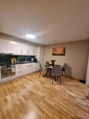 a kitchen and dining room with a table and chairs at Central Apartment Ålesund in Ålesund