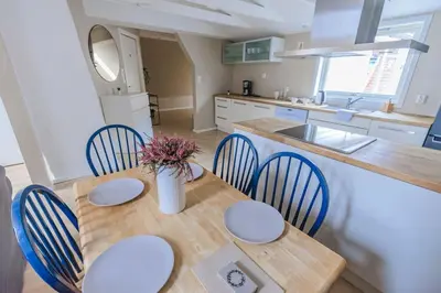 a kitchen with a wooden table with chairs and a counter at Supersentralt Bergen sentrum in Bergen