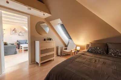 a bedroom with a large bed and a living room at Supersentralt Bergen sentrum in Bergen