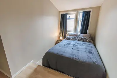a bedroom with a large bed with a window at Supersentralt Bergen sentrum in Bergen