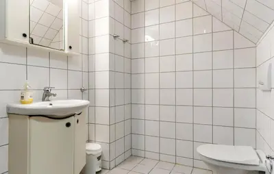 a white tiled bathroom with a sink and a toilet at Pet Friendly Apartment In Hemsedal in Hemsedal