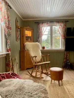 a living room with a rocking chair and a window at Friheten! in Notodden