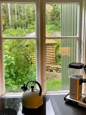 a tea kettle sitting on a stove in front of a window at Friheten! in Notodden