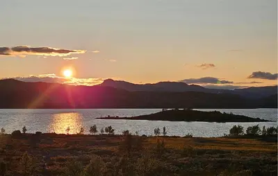 a sunset over a body of water with the sun setting at 2 Bedroom Cozy Apartment In Hemsedal in Hemsedal