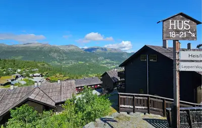 a sign in front of a black building with mountains at Pet Friendly Apartment In Hemsedal in Hemsedal