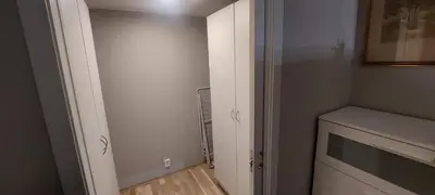 a small room with a closet with a microwave at Bergen city apartment in Bergen
