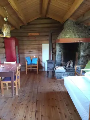 a living room with a fireplace and a table and chairs at Rondane Friluftssenter Rondetunet in Brenn