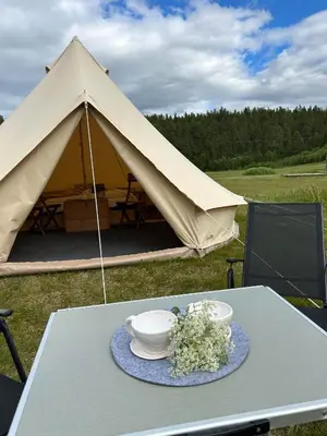 a table with a tent with two bowls and flowers on it at Rondane Friluftssenter Rondetunet in Brenn