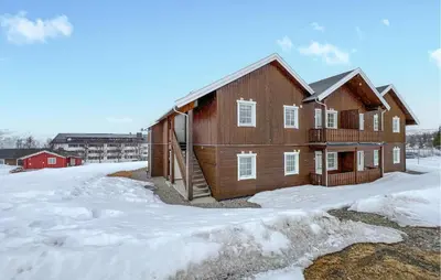 a brown barn with snow on the ground at 3 Bedroom Cozy Apartment In Gålå in Frya