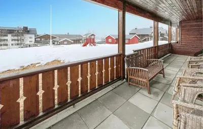 a porch with two chairs and a snow covered yard at 3 Bedroom Cozy Apartment In Gålå in Frya
