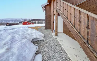 a snow covered sidewalk next to a wooden building at 3 Bedroom Cozy Apartment In Gålå in Frya