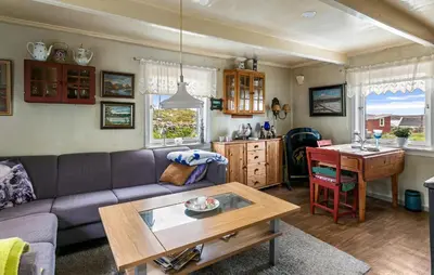 a living room with a couch and a table at Cozy Home In Norddyrøy With Kitchen in Sætra