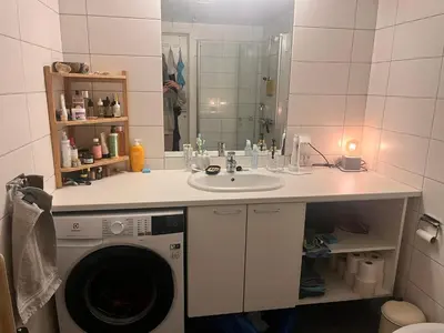 a bathroom with a sink and a washing machine at Seagull Holiday& Businnes Apartment in Trondheim