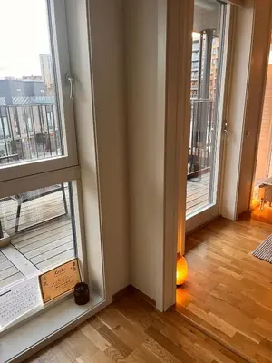a room with two large windows and a wooden floor at Seagull Holiday& Businnes Apartment in Trondheim