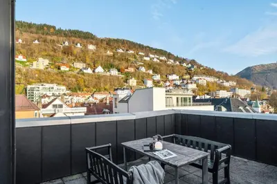 a table and chairs on a balcony with a view at Modern Apartment In The Heart of Bergen in Bergen