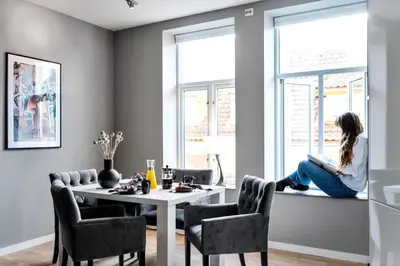 a woman sitting on a window sill reading a book at Modern Apartment In The Heart of Bergen in Bergen
