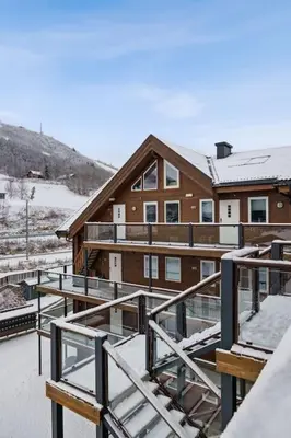 a building with snow on the roof of it at Moderne og sentral leilighet på Geilo in Geilo
