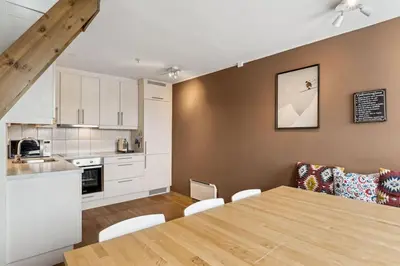 a kitchen and a dining room with a table and chairs at Moderne og sentral leilighet på Geilo in Geilo