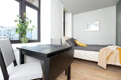 a bedroom with a desk and a bed in a room at Sentrumsnær studioleilighet! in Trondheim