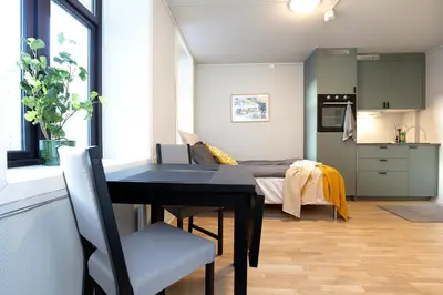 a room with a dining table and a bedroom at Sentrumsnær studioleilighet! in Trondheim