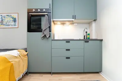 a kitchen with a refrigerator and a sink at Sentrumsnær studioleilighet! in Trondheim