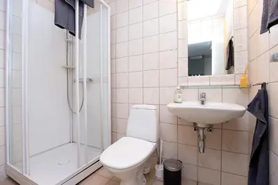 a bathroom with a toilet and a sink and a shower at Sentrumsnær studioleilighet! in Trondheim