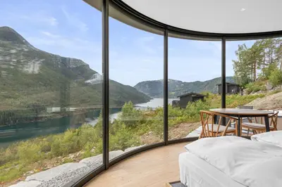 a bedroom with a view of a river and mountains at Sogndal Fjordpanorama- The Panorama View in Kaupanger