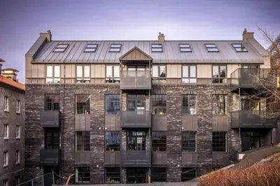 a large brick building with a metal roof at Stay l Luxurious Hideaway in Centrum in Bergen