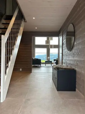 a hallway with a staircase and a living room at Nydelig hytte ved Voss Ski og Tursenter in Giljane