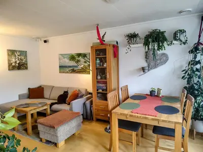 a living room with a table and a couch at Cozy room in a house with a garden on the island of Askøy, near Bergen in Askøy