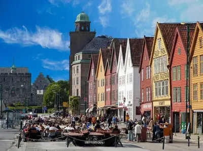 a group of people sitting at tables on a city street at Central stay apartment - 302 in Bergen