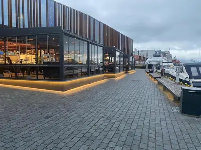 a building with windows and benches on a street at Central stay apartment - 302 in Bergen