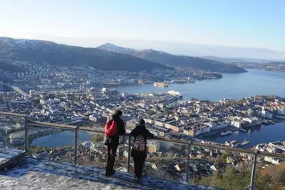 two people standing on top of a hill overlooking a city at Central stay apartment - 302 in Bergen
