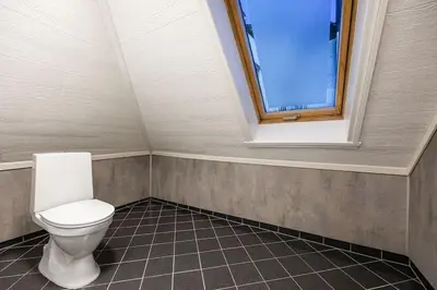 a bathroom with a toilet and a window at Central stay apartment - 401 in Bergen